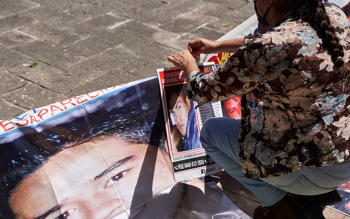 Miembros de Voz y Dignidad colocan imágenes y carteles de sus desaparecidos en el monumento al ser querido al final de la marcha por la conmemoración de el Día Internacional de las Víctimas de Desaparición Forzada convocada por familiares de personas desaparecidas y miembros de la Asociacion Voz y Dignidad por los Nuestros. 30 de Agosto del 2020. San Luis Potosi, Mexico. Mauricio Palos