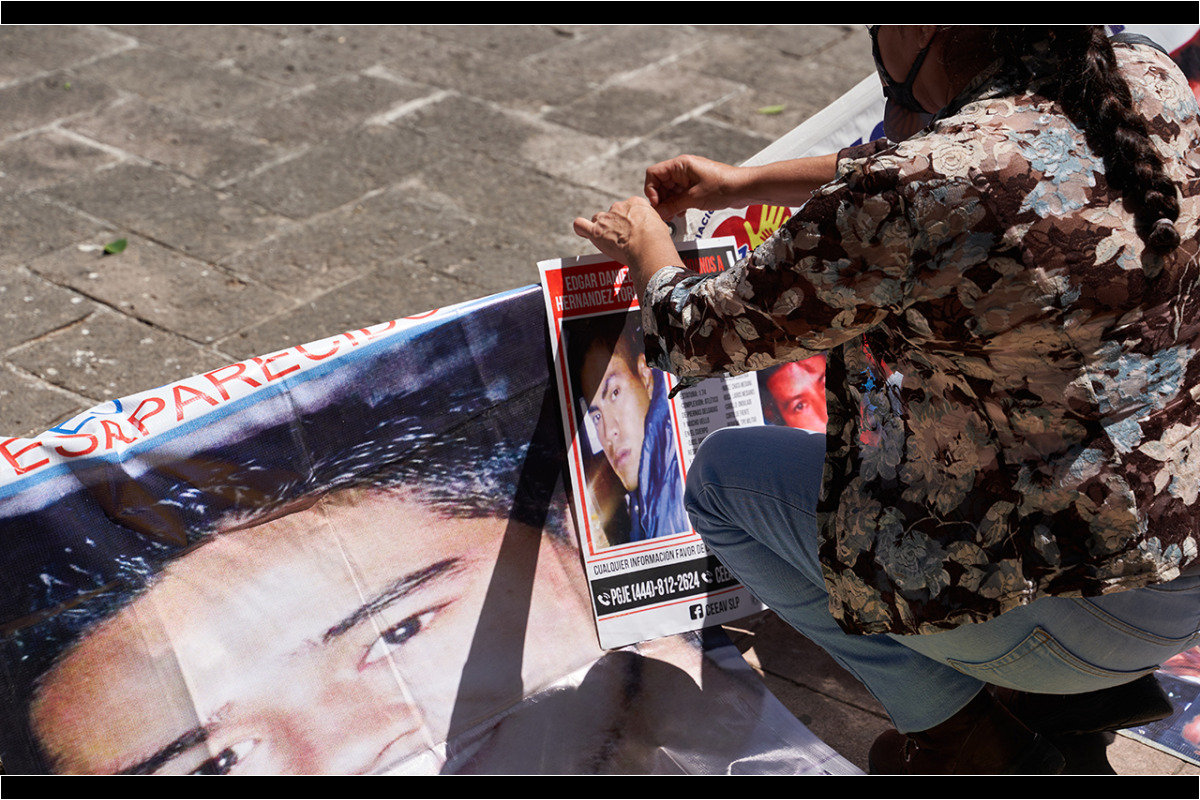 Miembros de Voz y Dignidad colocan imágenes y carteles de sus desaparecidos en el monumento al ser querido al final de la marcha por la conmemoración de el Día Internacional de las Víctimas de Desaparición Forzada convocada por familiares de personas desaparecidas y miembros de la Asociacion Voz y Dignidad por los Nuestros. 30 de Agosto del 2020. San Luis Potosi, Mexico. Mauricio Palos