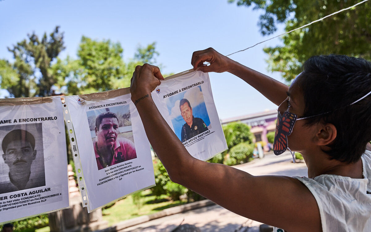 Miembros de Voz y Dignidad colocan imágenes y carteles de sus desaparecidos en el monumento al ser querido al final de la marcha por la conmemoración de el Día Internacional de las Víctimas de Desaparición Forzada convocada por familiares de personas desaparecidas y miembros de la Asociacion Voz y Dignidad por los Nuestros. 30 de Agosto del 2020. San Luis Potosi, Mexico. Mauricio Palos