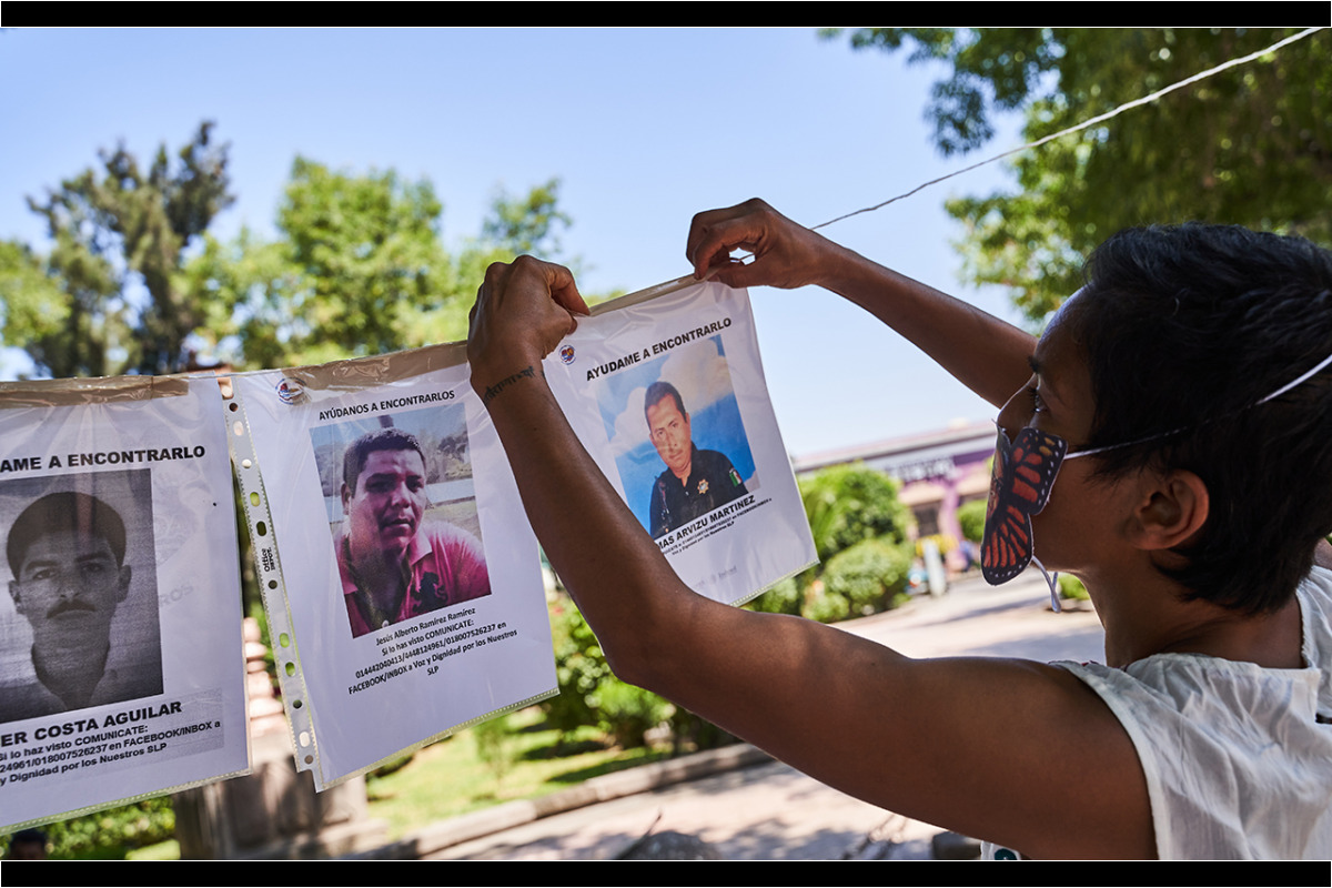 Miembros de Voz y Dignidad colocan imágenes y carteles de sus desaparecidos en el monumento al ser querido al final de la marcha por la conmemoración de el Día Internacional de las Víctimas de Desaparición Forzada convocada por familiares de personas desaparecidas y miembros de la Asociacion Voz y Dignidad por los Nuestros. 30 de Agosto del 2020. San Luis Potosi, Mexico. Mauricio Palos