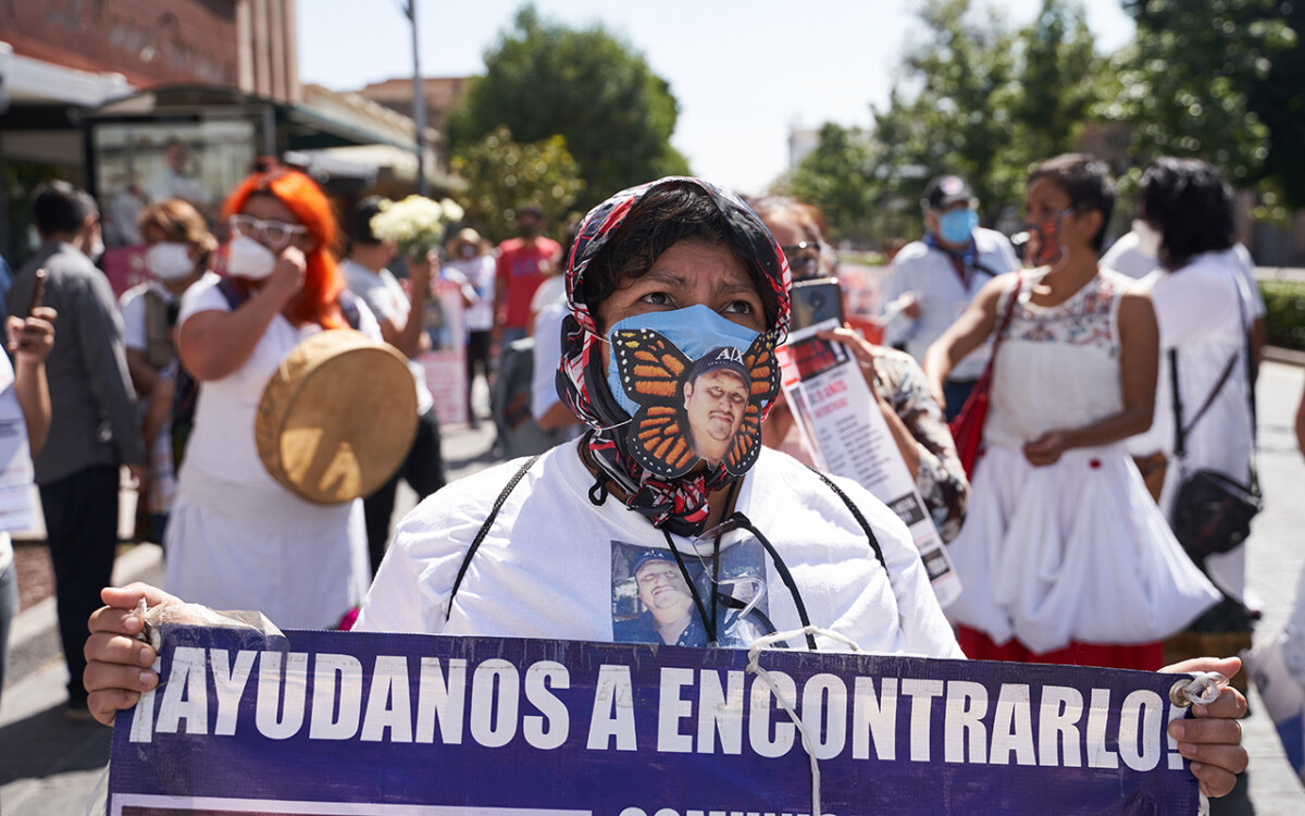 La imagen de Juan Carlos Martinez Hernandez desaparecido el 1 de abril del 2017, unos jóvenes con armas largas lo detuvieron, encañonaron y subieron a una camioneta en la carretera de El Naranjo, San Luis Potosí aparece en un cubrebocas durante la marcha por la conmemoración de el Día Internacional de las Víctimas de Desaparición Forzada convocada por familiares de personas desaparecidas y miembros de la Asociacion Voz y Dignidad por los Nuestros. 30 de Agosto del 2020. San Luis Potosi, Mexico. Mauricio Palos