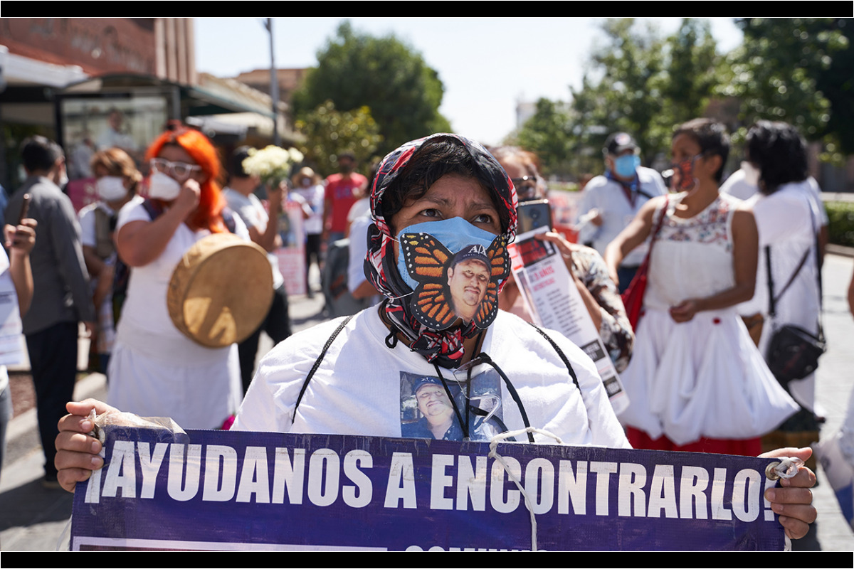 La imagen de Juan Carlos Martinez Hernandez desaparecido el 1 de abril del 2017, unos jóvenes con armas largas lo detuvieron, encañonaron y subieron a una camioneta en la carretera de El Naranjo, San Luis Potosí aparece en un cubrebocas durante la marcha por la conmemoración de el Día Internacional de las Víctimas de Desaparición Forzada convocada por familiares de personas desaparecidas y miembros de la Asociacion Voz y Dignidad por los Nuestros. 30 de Agosto del 2020. San Luis Potosi, Mexico. Mauricio Palos