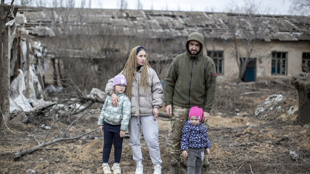 Tatyana Shervakova, ingeniera de radio de 31 años, es fotografiada cerca de la escuela local destruida por los bombardeos durante un día libre junto a su marido Alexy, de 28 años, ingeniero mecánico especialista que se ha unido al Batallón de Asalto Aéreo de la Brigada 81 del Ejército Ucraniano, y sus dos hijas, Mariana, de 3 años, y Alina, de 6, en la aldea de Ivanivka, situada a 14 km detrás del campo de batalla de Ocheteryne. A pesar de los intensos bombardeos sobre la región y del convencimiento mostrado por Alexy de alejar a su familia hacia un lugar más seguro en el oeste, Tatyana está decidida a permanecer en su hogar hasta el último momento debido a la falta de posibilidades que tiene su familia de sobrevivir económicamente en el oeste, haciendo frente a la inflación y al elevado coste del alojamiento mientras su salario familiar depende de un puesto de comida, un negocio familiar en el que Tatyana vende café y comida rápida a los soldados desplegados en la línea del frente, Ivanivka, Óblast de Donetsk, 03 de marzo de 2024.