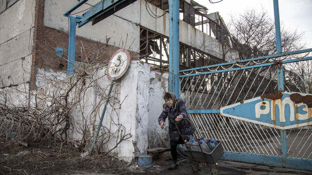 Un anciano recoge agua en botellas de plástico de un grifo fuera de una fábrica parcialmente destruida en las afueras de Toretsk, una ciudad en primera línea bajo un intenso bombardeo en el este de la región de Donetsk, mientras continúan los combates entre las fuerzas ucranianas y las tropas rusas en Donbas, Ucrania, 02 de marzo 2024.