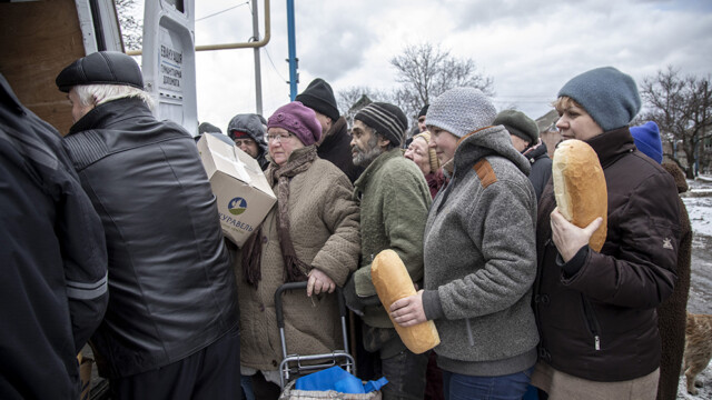 Civiles locales hacen cola para la distribución de ayuda humanitaria por parte del pastor Oleg, de la Misión Samaritan's Purse, y el pastor Leonid, de la Misión Good News de una iglesia ortodoxa, en el centro de Ocheretyne, un pueblo sometido a intensos bombardeos en las inmediaciones del distrito de Avdiivka, recientemente reclamado por las tropas rusas en Donbás, Ucrania, 19 de febrero de 2024.